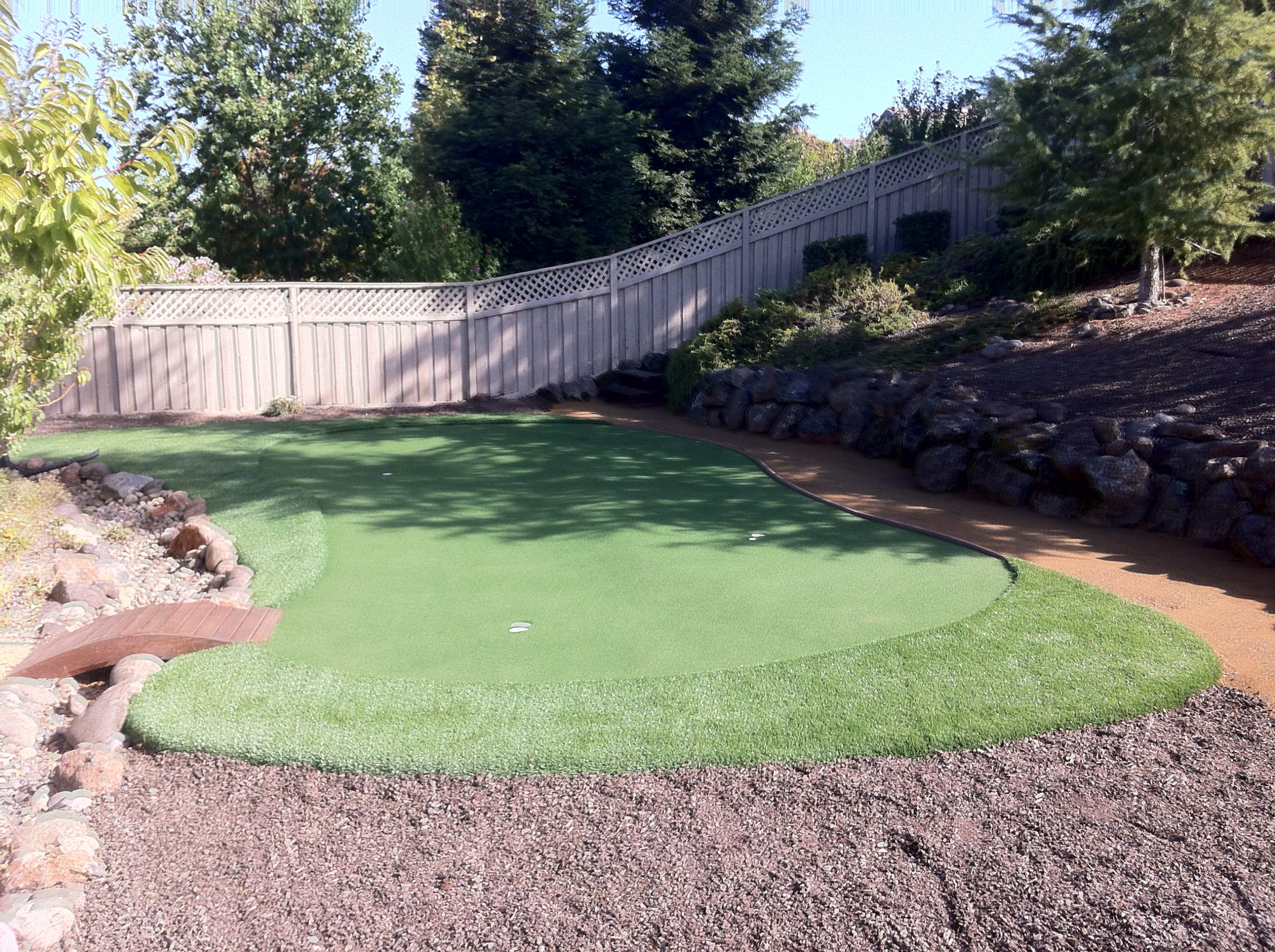 Backyard artificial turf putting green with 3 cups